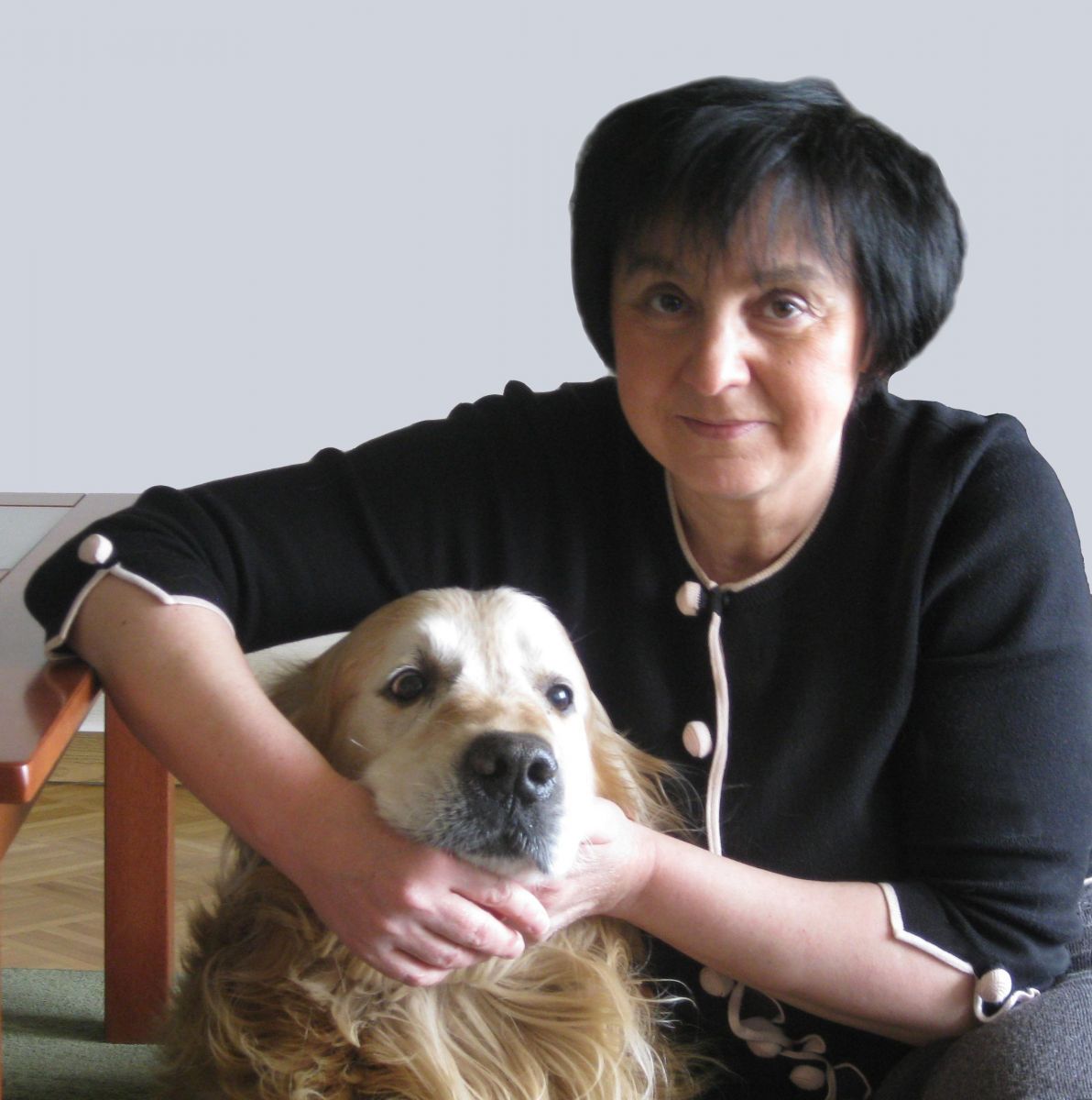 Fotografia portretowa Renata Piątkowska: uśmiechnieta kobieta w krótko ściętych włosach, trzyma obok siebie psa.