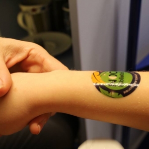 przedramię dziecka z tatuażem zmywalnym, który przedstawia logo akcji noc bibliotek