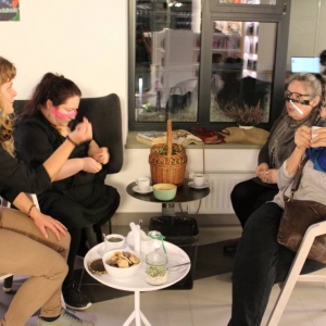 cztery kobiety siedzące przy białym stole, popijają herbatę