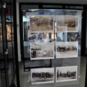 Pomiędzy przeszklonymi drzwiami i czarnymi ramami w wystawowych ramach umieszczone jest 6 zdjęć  formatu A4 przedstawiające powstańców oraz wydarzenia rozgrywane na Górnym Śląsku sto lat temu. Z prawej strony stoi nie wysoki stolik oraz dwa bujane krzesła.